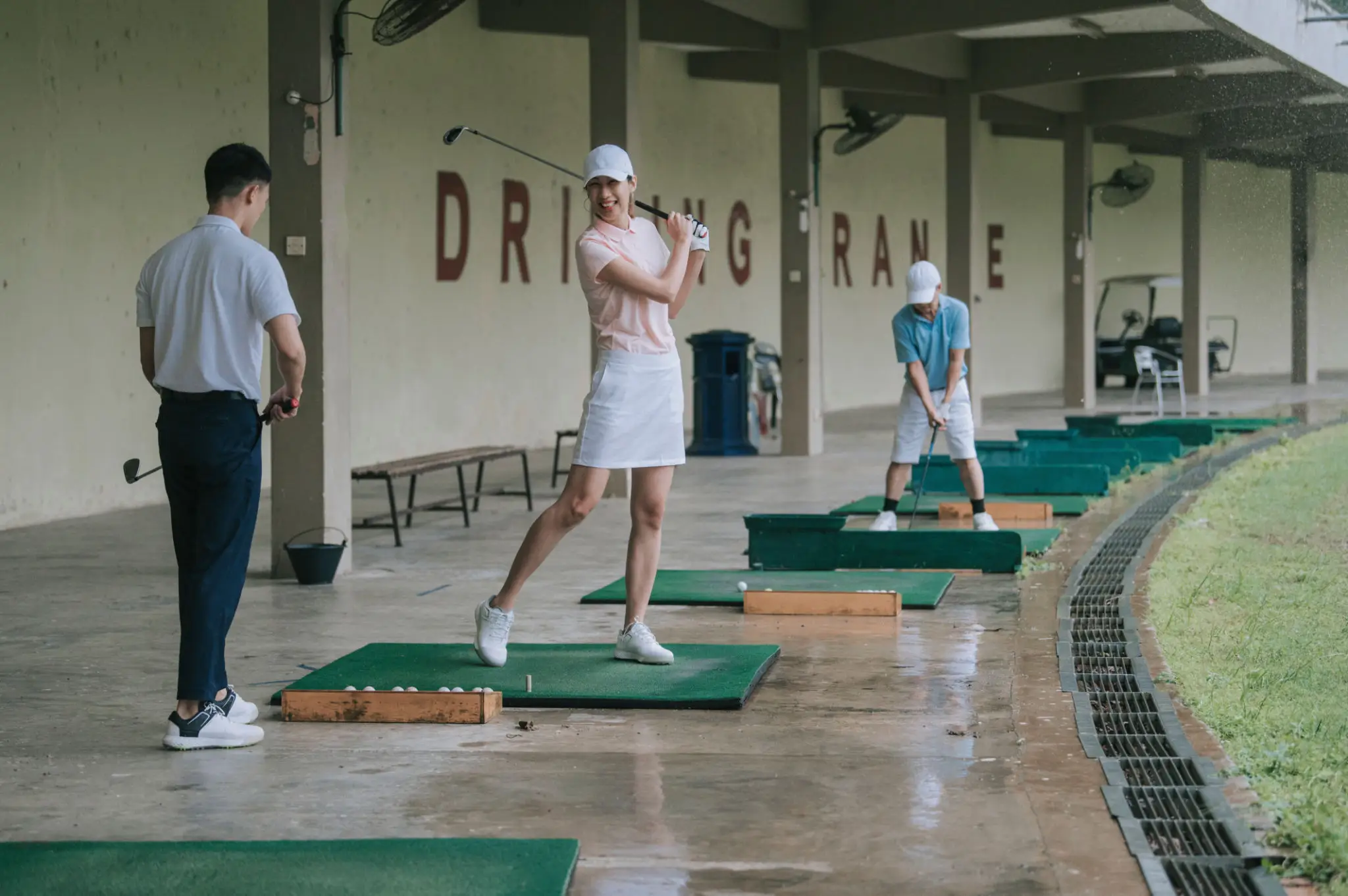 People practicing golf at a driving range.