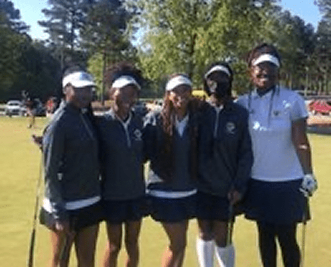 Golf team posing on the green.